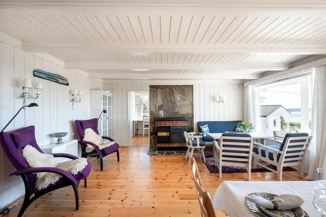Romslig stue med store vinduer mot vannet