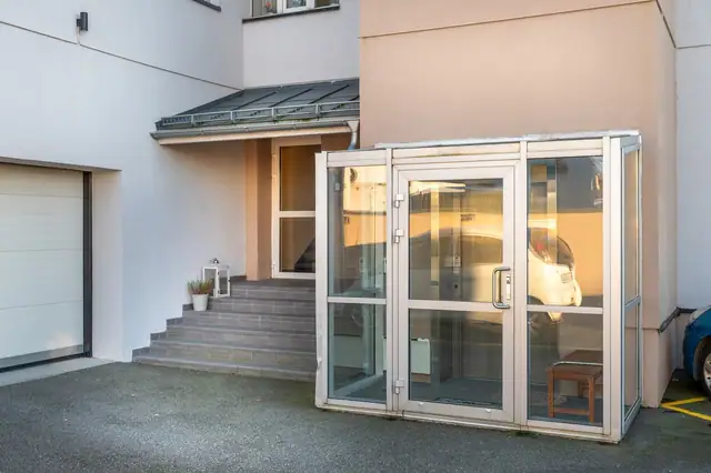 Inngangsparti med heisadkomst og port til garasjeanlegg