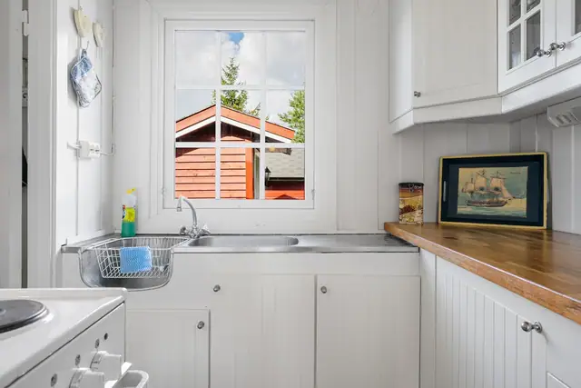 Frittstående komfyr og kjøleskap med frysedel.