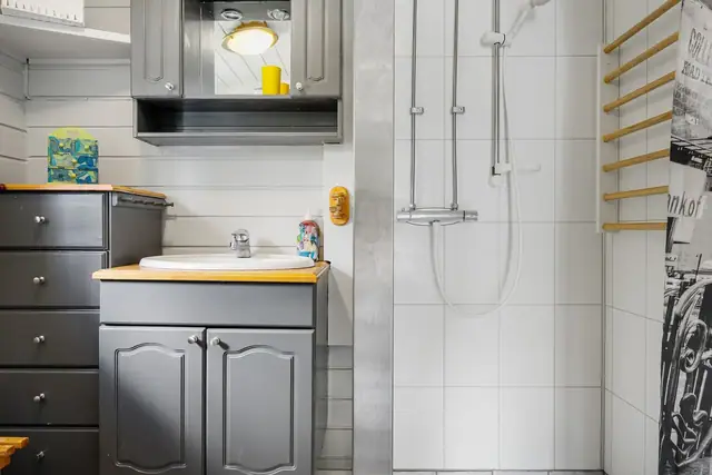 Badet er innredet med servantinnredning og dusjhjørne.