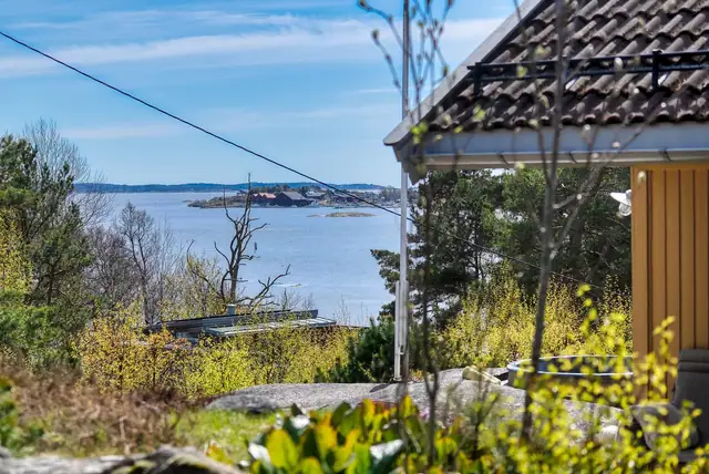Innbydende familiehytte med stor solrik naturtomt, sjøutsikt, 4 soverom, båtplass og badestamp.