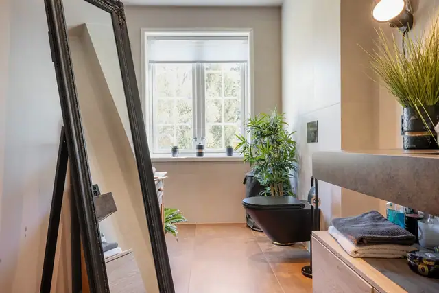 Stilrent bad i første etasje fra xx med romslig dusjhjørne, moderne storformat fliser, servant og toalett.