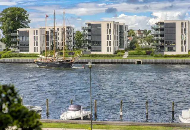 Denne utsikten kan bli din.  Det skjer alltid noe på elven.  Her kan du følge lystbåter og store skip på vei opp og ned elveløpet.   Bildet kan oppleves dramatisk, men alt gikk etter planen når skuta i bildet skulle vende om.