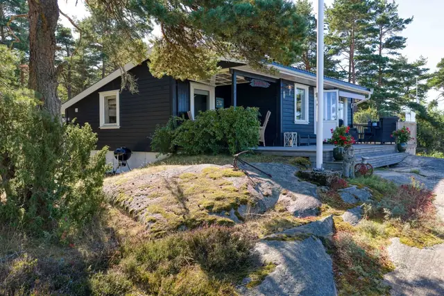 Hytta ligger svært pent blant nydelige furutrær, svaberg og sjø
