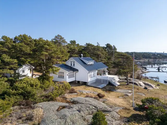 Hytta ligger tett på vannspeilet med egen brygge